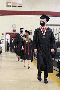 graduates walking in a single file into the gymnasium at the beginning of the ceremony