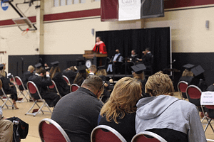 view of commencement platform from behind guests sitting in chairs