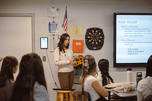 image of Cairn student standing next to a Smart Board and giving a presentation